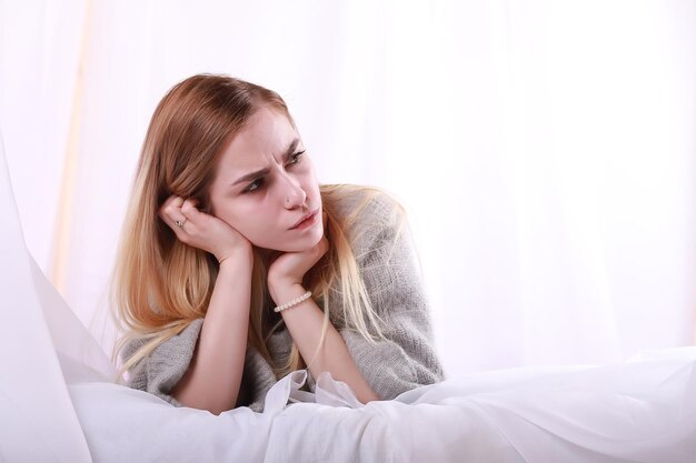 La ragazza con i capelli biondi e il maglione grigio posa