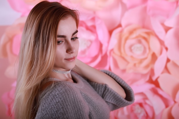 Girl with blond hair and gray sweater poses