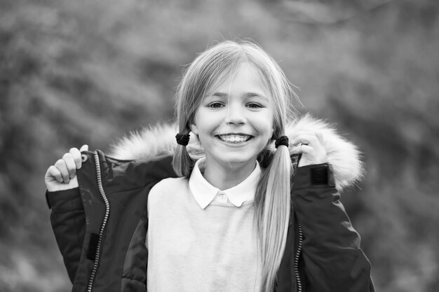 Girl with blond hair ponytail smile on natural landscape