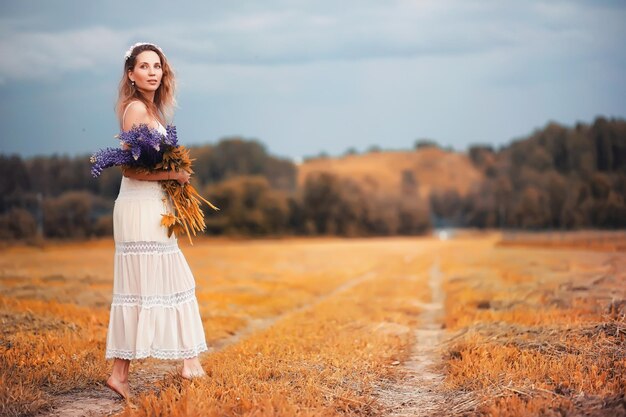 Girl with a bouquet of flowers in autumn