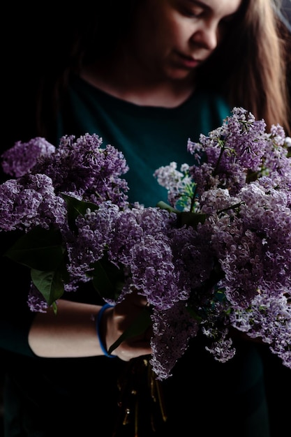A girl with a bouquet of lilacs