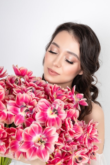 ピンクのチューリップの花束を持つ少女花の贈り物を持つ少女