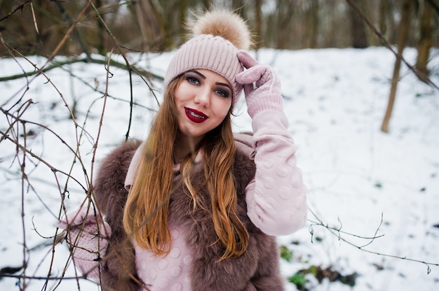 Girl with braces at winter day wear on fur coat and headwear.