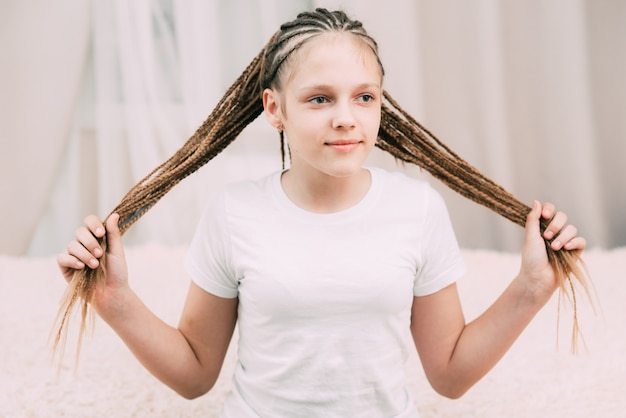 Girl with brown hair and pigtails braided with artificial hair