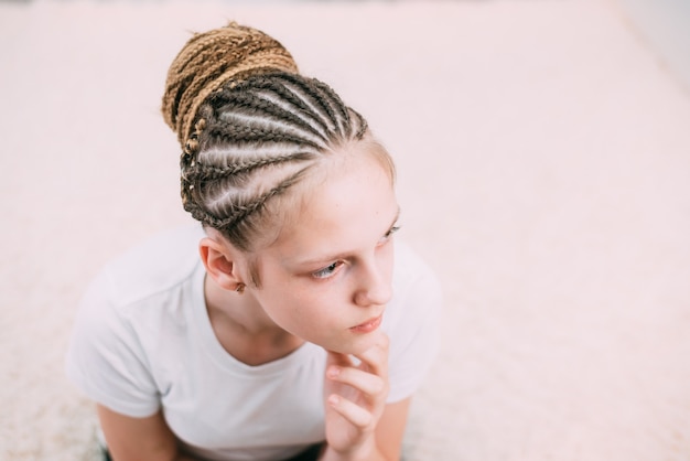 Girl with brown hair and pigtails braided with artificial hair