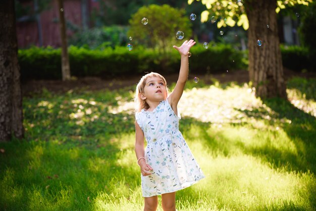 Girl with bubbles at a sunny summer evening.