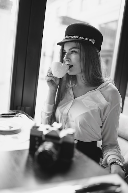 Girl with a camera and coffee, black and white