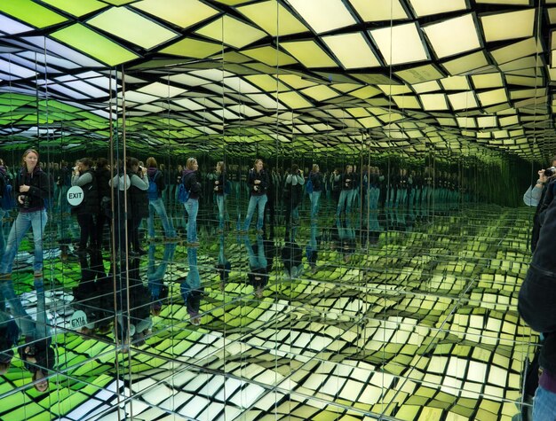 Girl with a camera in a mirrored room with reflections which is part of the exhibition in greece