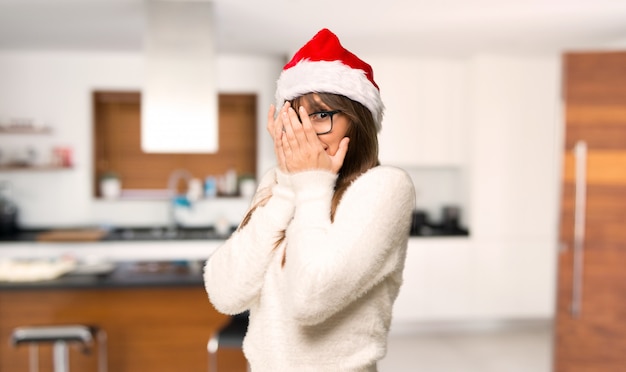 Girl with celebrating the christmas holidays covering eyes by hands