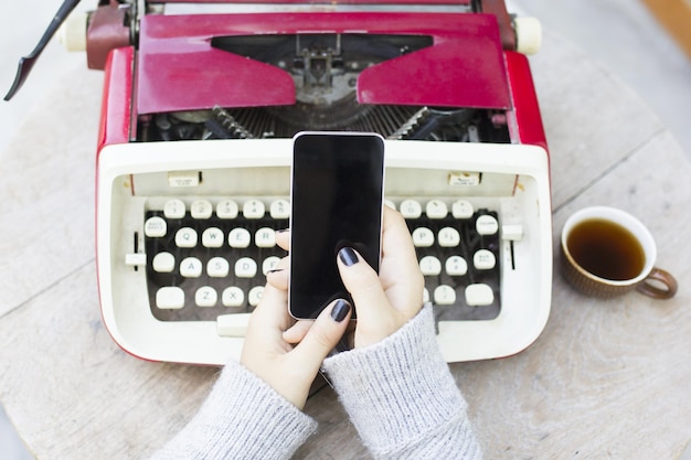 Girl with cell phone and typewriter