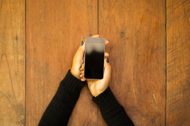 Девушка с мобильным телефоном на деревянном фоне