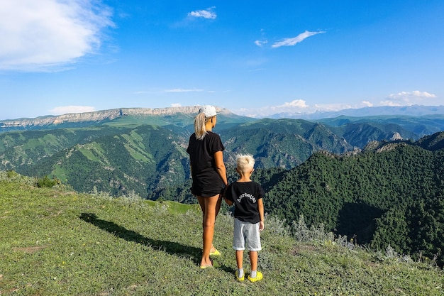 A girl with a child on the background of the Caucasus Mountains near the tract of JilaSu KabardinoBalkaria