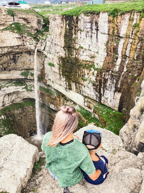 A girl with a child on the background of the Tobot waterfall Khunzakh waterfalls Dagestan Russia 2021