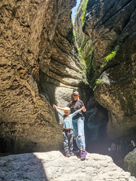 A girl with a child in a canyon in a mountain gorge on the way to the Saltinsky waterfall Russia Dagestan June 2021