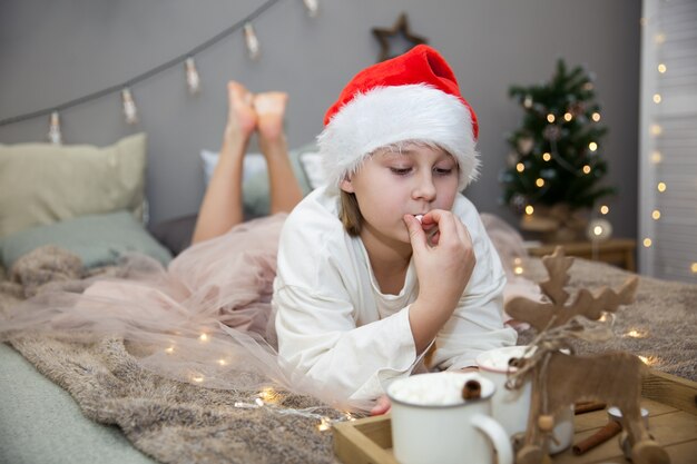 ベッドでクリスマスの朝食を持つ女の子