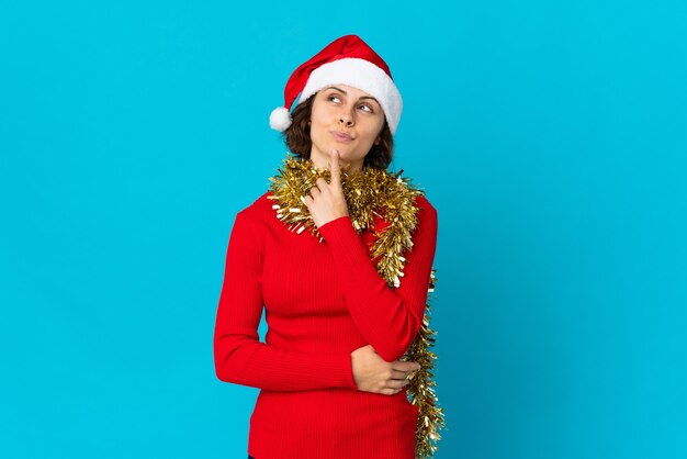 Ragazza con cappello di natale su sfondo blu