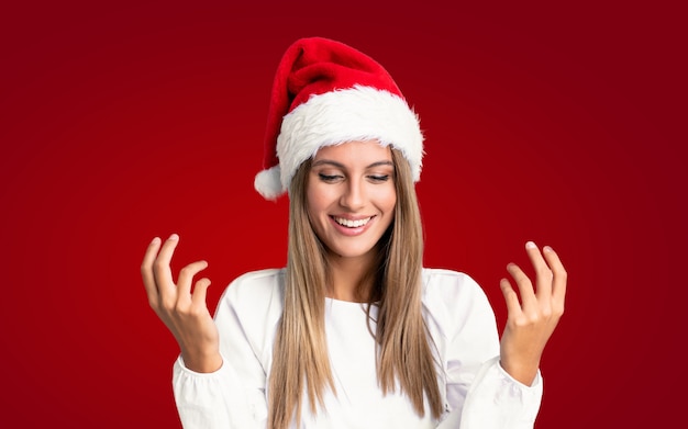 Girl with christmas hat over isolated wall laughing