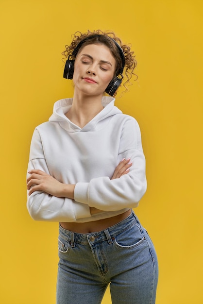 Girl with closed eyes listening to music in earphones