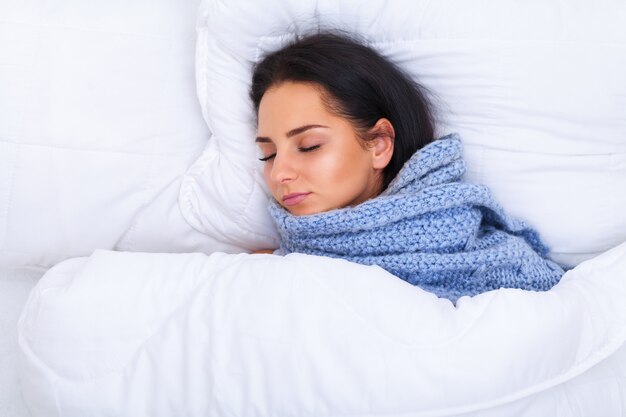 Girl with cold lying under a blanket