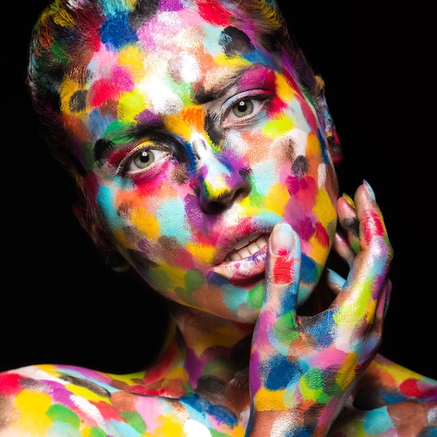 Foto ragazza con la faccia colorata dipinta. immagine di bellezza di arte.