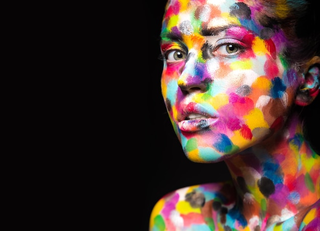 Girl with colored face painted. Art beauty image.