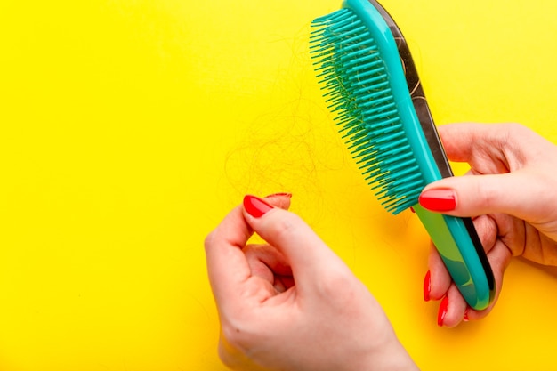 Girl with a comb and problem hair on white background.