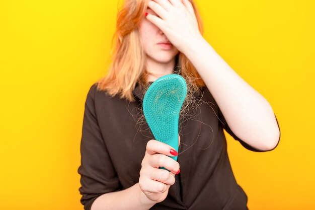 Girl with a comb and problem hair on white background