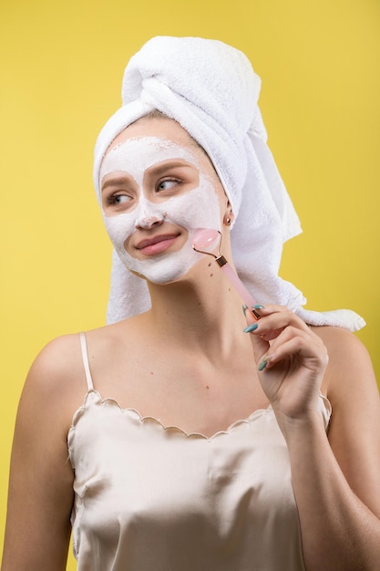 Photo girl with a cosmetic mask on her face in a white towel