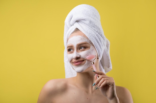 Girl with a cosmetic mask on her face in a white towel.