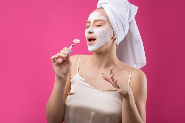 Girl with a cosmetic mask on her face in a white towel.