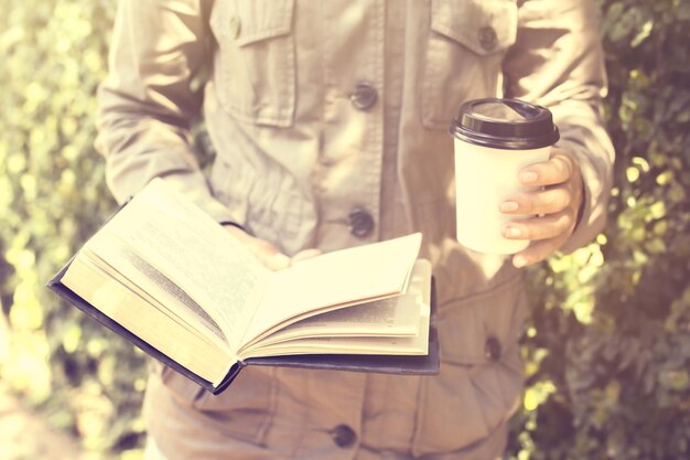 Ragazza con una tazza di caffè e un effetto foto d'epoca libro