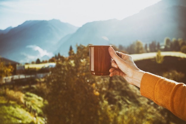 Girl with a cup of coffee. picture taken through window glass. morning at dawn