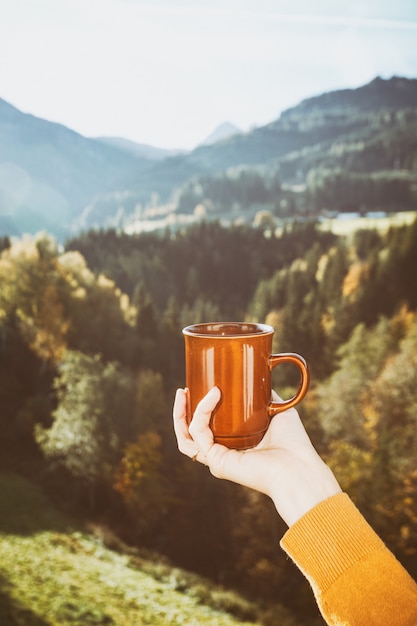 Girl with a cup of coffee. picture taken through window glass. morning at dawn