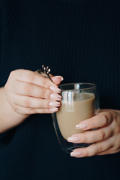 彼女の手にホットコーヒーのカップを持つ女の子