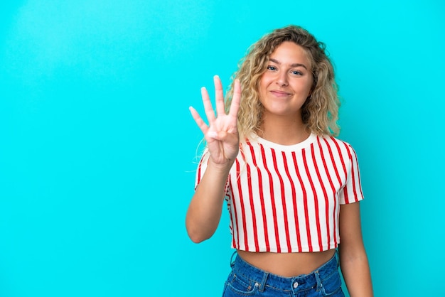 Girl with curly hair isolated on blue background happy and counting four with fingers