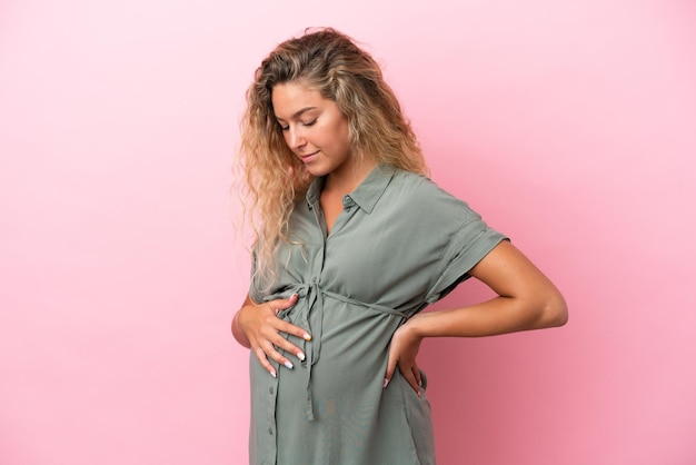 Girl with curly hair isolated on pink background pregnant