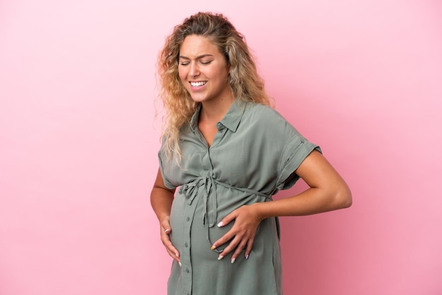 Girl with curly hair isolated on pink background pregnant