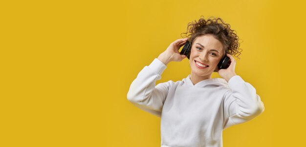 Girl with curly hair standing with earphones