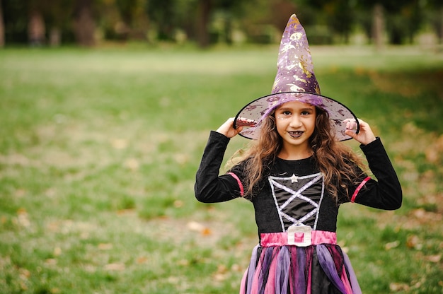 Girl with curly hair in a witch costume for Halloween