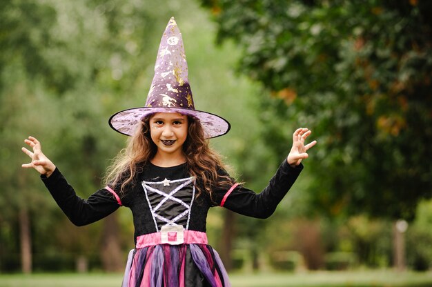 Ragazza con i capelli ricci in un costume da strega per halloween