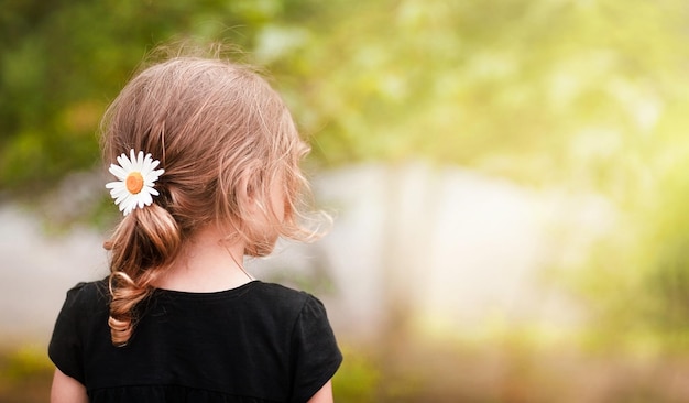 girl with a daisy in curly hair