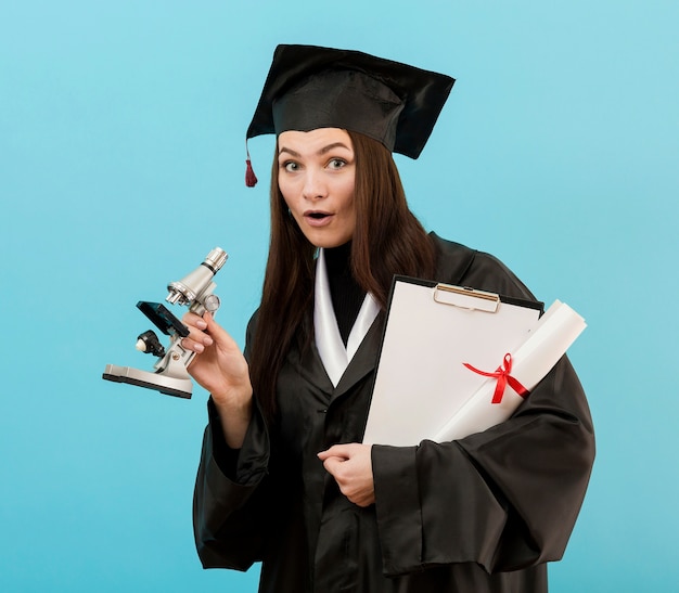 Ragazza con diploma e microscopio