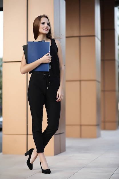 Girl with documents at a business meeting near a modern building