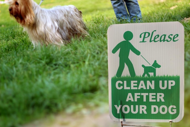 Photo girl with a dog outside the warning sign clean up after your dog