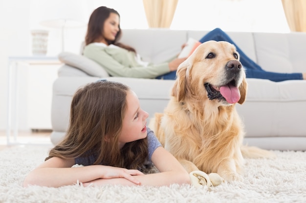 家庭の敷物に犬を持つ少女