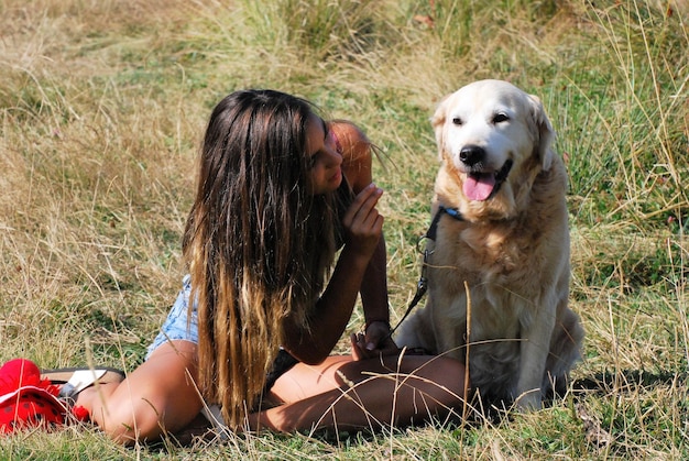 Photo girl with dog sitting on grass