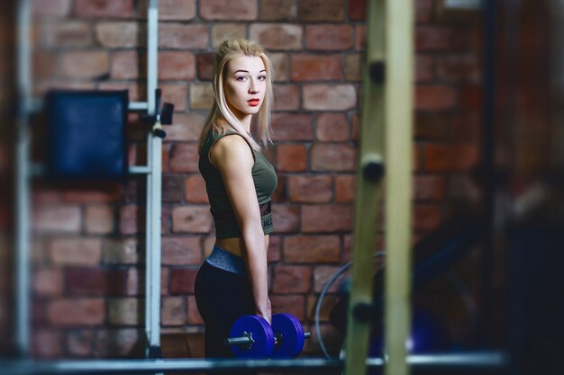 Girl with dumbbell in gym