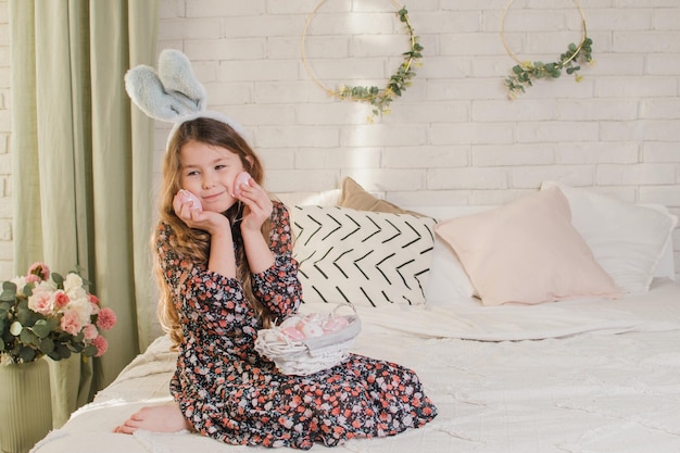 Girl with easter basket on bed