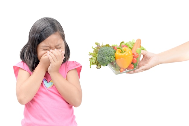 girl with expression of disgust against vegetables 