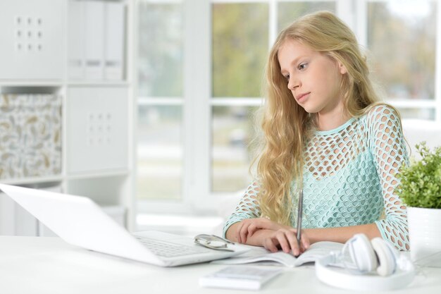 Ragazza con gli occhiali seduto alla scrivania